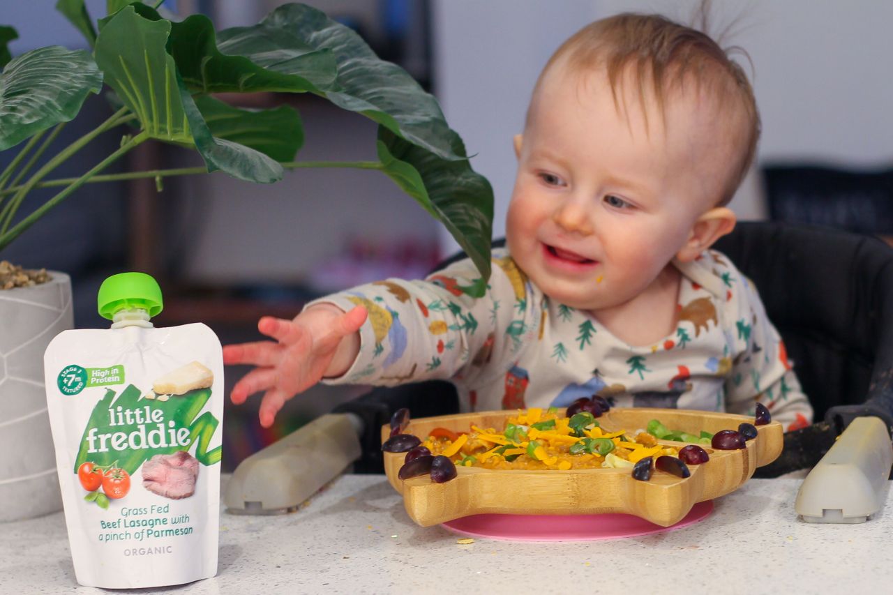 Baby led weaning at 1 year old old - baby reaching for pouch of food