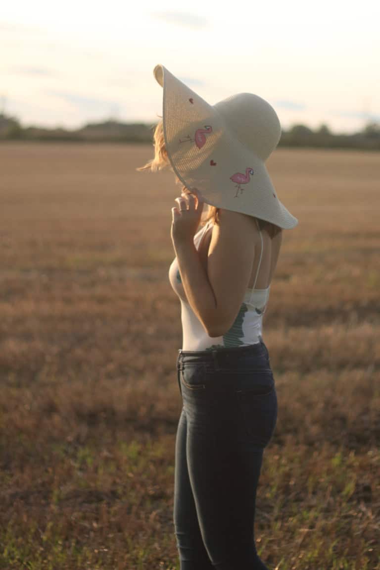Tobi palm print bodysuit with floppy flamingo hat and jeans