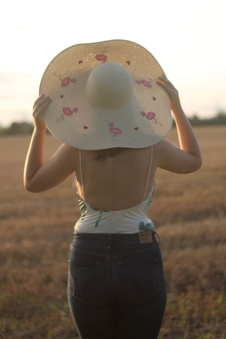 Tobi palm print bodysuit with floppy flamingo hat and jeans